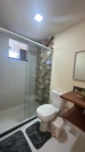 une salle de bains avec toilettes et douche en verre dans l'établissement Águas cristalinas 01, à Cabo Frio 4 autres photos