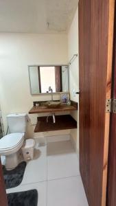 une salle de bains avec toilettes, lavabo et miroir dans l'établissement Águas cristalinas 01, à Cabo Frio