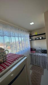 une cuisine avec une fenêtre et un comptoir avec une table dans l'établissement Águas cristalinas 01, à Cabo Frio