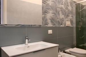 Un baño con lavabo, inodoro y espejo. en Luxury Apartments Schiavonea, en Marina di Schiavonea
