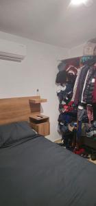 a room with a bed and a rack of clothes at Habitacion in Monterrey