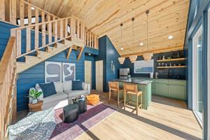 a kitchen and living room with a staircase in a house at Apate Treehouse Lux Hot tub Fredericksburg EV BBQ in Fredericksburg