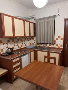 kuchnia z drewnianymi szafkami i drewnianym stołem w obiekcie Antonia Apartments w Firze