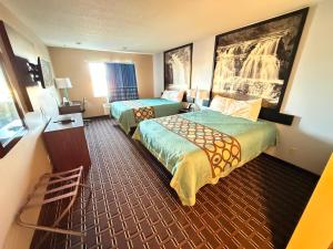 a hotel room with two beds and a window at Super 8 by Wyndham Reedsburg in Reedsburg +29 photos