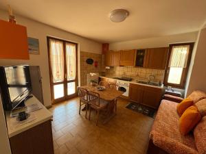 a kitchen with a table and a kitchen with a couch at Casa Bruna in Vervio