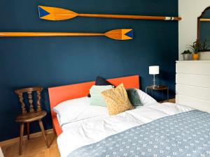 a bed with an orange headboard and a blue wall at Lake Life in Sankt Gilgen +26 photos