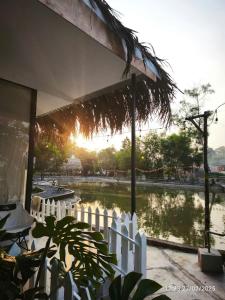 una cerca blanca frente a un estanque en Homestay Mẹ khang 2 - Room lake view, en Cu Chi