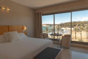 a bedroom with a bed and a view of the beach at La Sort Boutique Hotel in Moraira