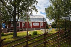 une grange rouge avec une clôture devant elle dans l'établissement Amalia, à Lemland