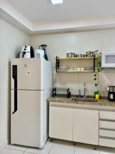 a kitchen with a white refrigerator and a counter at Desativado in São Luís