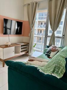 a living room with a green couch and a tv at Desativado in São Luís