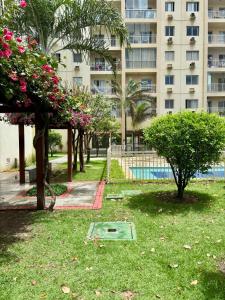 a park in front of a building with flowers at Desativado in São Luís