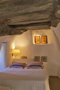 a bedroom with a white bed with two pillows at Aegean Bliss Villa - Hydroussa in Andros +29 photos