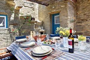 a table with plates and glasses and a bottle of wine at Aegean Bliss Villa - Hydroussa in Andros