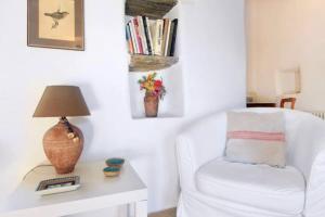 a living room with a white chair and a table at Aegean Bliss Villa - Hydroussa in Andros