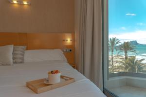 a bedroom with a bed with a view of the beach at La Sort Boutique Hotel in Moraira