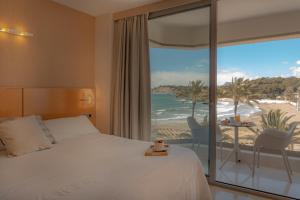 a bedroom with a bed and a view of the beach at La Sort Boutique Hotel in Moraira