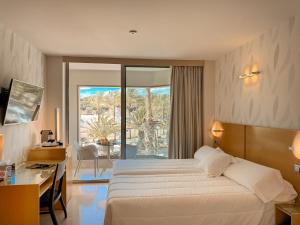 a hotel room with a bed and a desk and a window at La Sort Boutique Hotel in Moraira