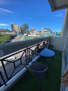 a balcony with chairs and a table and a street at LJ's Burnham Homestay in Baguio