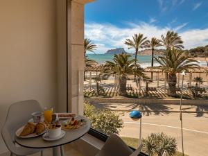 a room with a table with food and a view of the beach at La Sort Boutique Hotel in Moraira