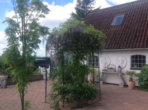 un árbol en una jaula delante de una casa en Bed and Breakfast - Stakdelen 47, en Allerup