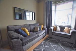 a living room with a couch and a chair at Central Cheerful Comfortable 3 Bedroom Home in Pallion +20 photos