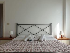 un letto con due paia di scarpe sopra di IL MARE DI ROMA APARTMENT a Lido di Ostia