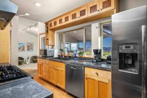 a kitchen with wooden cabinets and stainless steel appliances at Dogwood Villa in Dundee