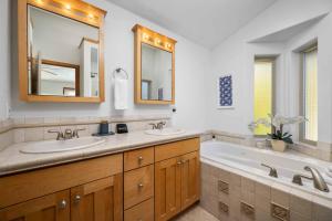 a bathroom with two sinks and a tub and two mirrors at Dogwood Villa in Dundee +41 photos