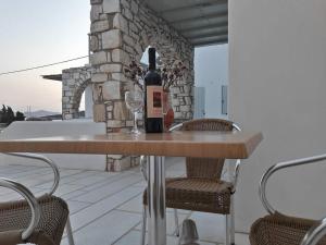a bottle of wine sitting on a table on a patio at Stavento Apartments in Aliki +28 photos