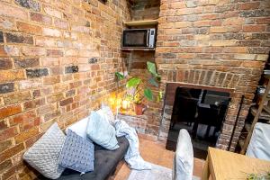 a brick wall with a couch in front of a fireplace at Fitzroy- Private rooms 2-4 guest #GuestHouse #AusGP #DirectTram #F1 in Melbourne