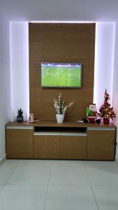 a room with a television with a soccer game on it at FLAT Maré Alta - Porto de Galinhas in Porto De Galinhas