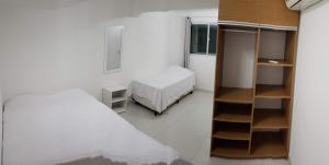 a bedroom with a bed and a book shelf at FLAT Maré Alta - Porto de Galinhas in Porto De Galinhas