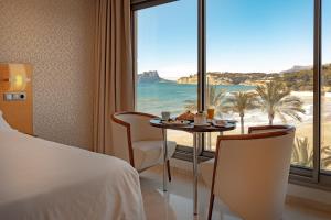 a hotel room with a table and a view of the beach at La Sort Boutique Hotel in Moraira