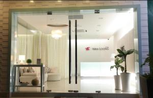 a glass window in a living room with a couch at Wan Loong Hote1 in Pontian Kecil