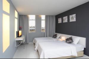 a hotel room with two beds and a television at Wan Loong Hote1 in Pontian Kecil