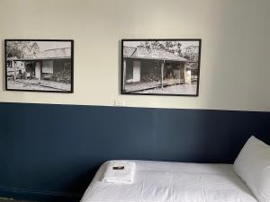 a bedroom with three pictures on the wall at Royal Hotel Oberon in Oberon
