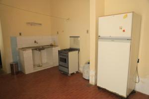 a kitchen with a white refrigerator and a sink at Casa Rústica e Aconchegante em Camocim in Camocim +7 photos