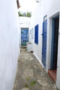 an alley between two white buildings with blue gates at Casa Rústica e Aconchegante em Camocim in Camocim
