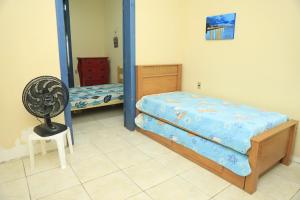 a bedroom with a bed and a fan and a mirror at Casa Rústica e Aconchegante em Camocim in Camocim
