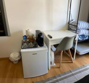 a small room with a table and a desk with a coffee maker at Casa de Vasco-Estadia Familiar e Tranquila in Amora