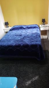 un letto con piumone blu in una camera di Casa con vista al mar, Punta negra, Maldonado a Punta Ballena