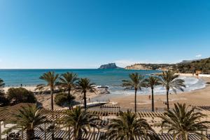 a view of a beach with palm trees and the ocean at La Sort Boutique Hotel in Moraira