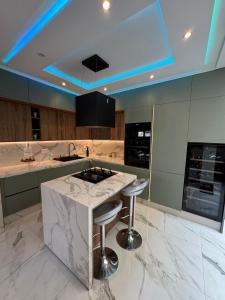 Una cocina con encimera de mármol blanco y taburetes. en Beautiful new modern house with full comfort, en Marrakech