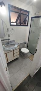a bathroom with a shower and a toilet and a sink at Apartamento em Enseada Guarujá in Guarujá