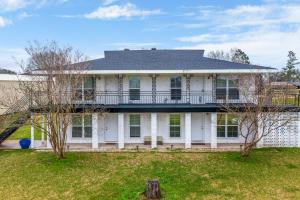 ein weißes Haus mit Balkon auf einem Hof in der Unterkunft Secret Cajun Retreat Peaceful Corner Stay - HAR 2 in Iowa