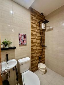 a bathroom with a toilet and a sink at Lydelles Guesthouse in Butuan