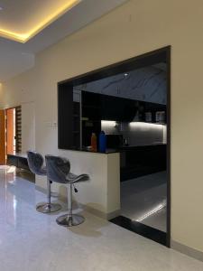 a living room with two chairs and a large television at Vidhyashree Illam in Madurai