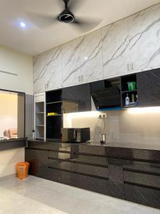 a kitchen with black and white marble counter tops at Vidhyashree Illam in Madurai