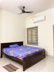 a bedroom with a bed and a ceiling fan at Vidhyashree Illam in Madurai